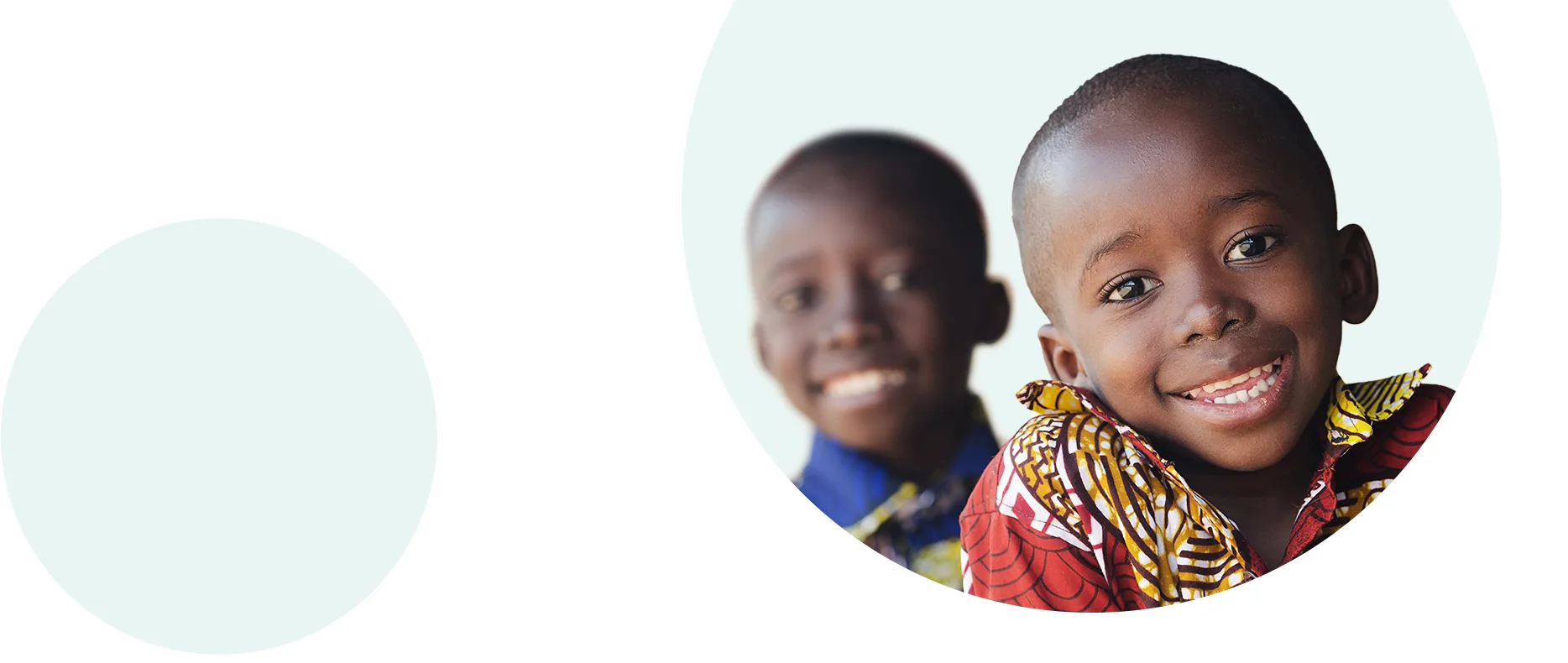 Two children laughing joyfully while waving at the camera.